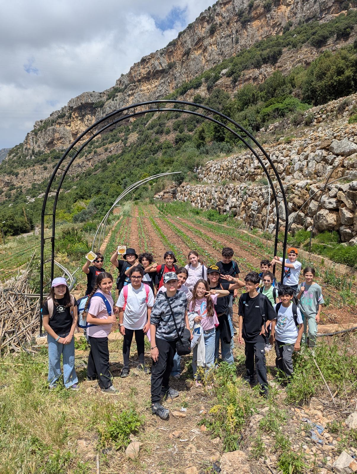 Students standing in front of the farm arch during a learning visit